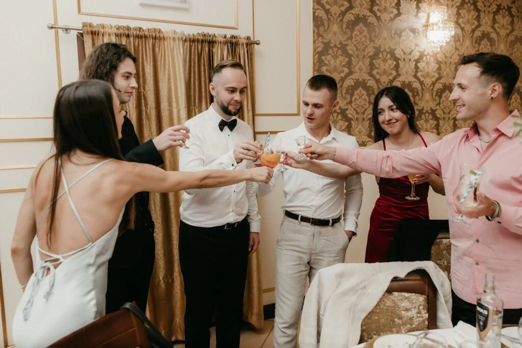 Grupa przyjaciół wznosi toast podczas wesela lub przyjęcia