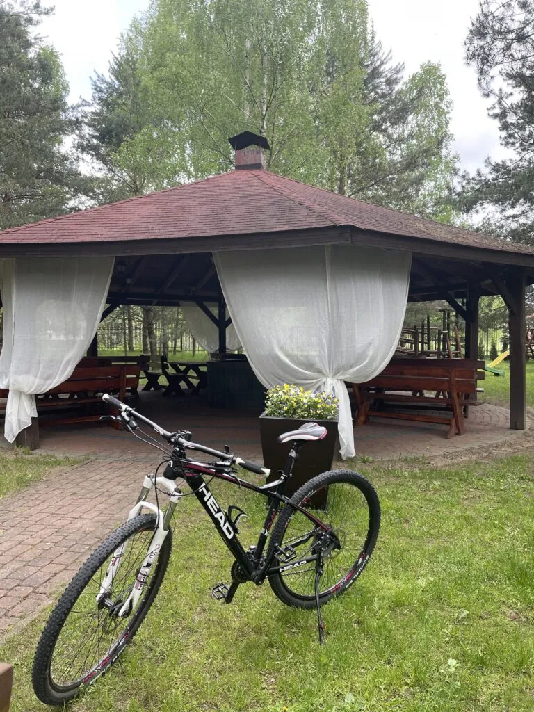 Rower górski zaparkowany przed altaną ogrodową w obiekcie Hotel Dworek Tryumf