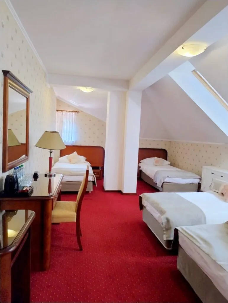 Wieloosobowy pokój hotelowy na poddaszu w obiekcie Dworek Tryumf.