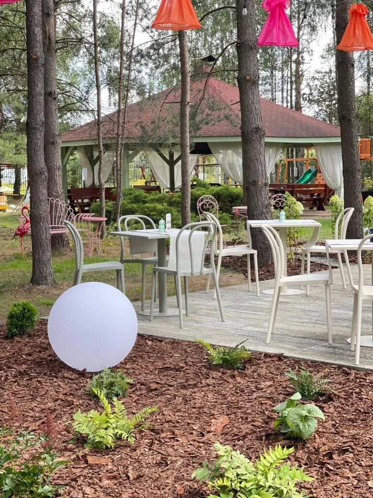 Taras restauracyjny z kulą świetlną i altaną w ogrodzie Dworku Tryumf.