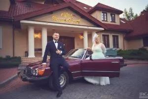 Para młoda w Hotelu Dworek Tryumf przy stylowym samochodzie.
