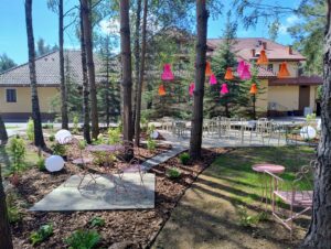 Taras Dworek Tryumf: stoliki, krzesła, ozdoby, budynek hotelowy