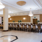Elegancka sala weselna w Dworku, udekorowana kryształowymi żyrandolami i złotymi akcentami