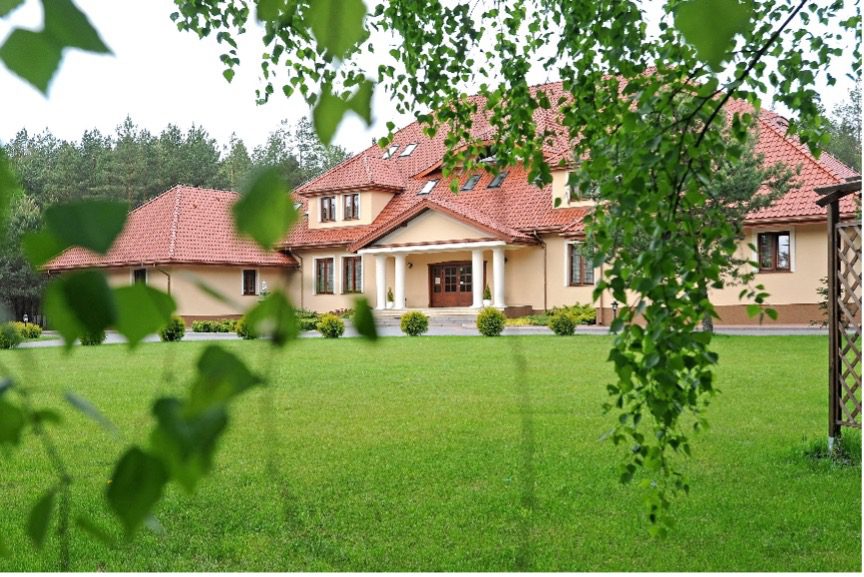 Elegancki dworek tryumf z dachem w otoczeniu zieleni